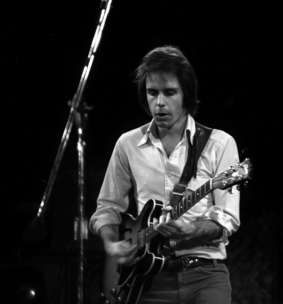 Bob Weir in 1975, playing guitar on stage.
